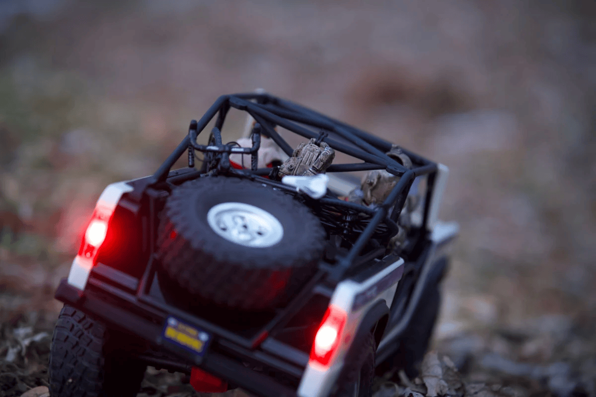 Close-up of a toy SUV navigating rocky terrain, with toy soldiers inside.