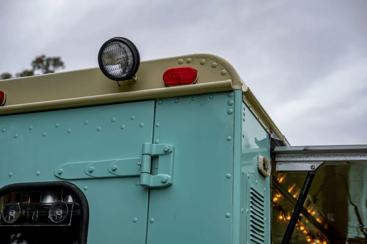Detailed view of a vintage food truck with lights and serving hatch, ideal for street food themes.