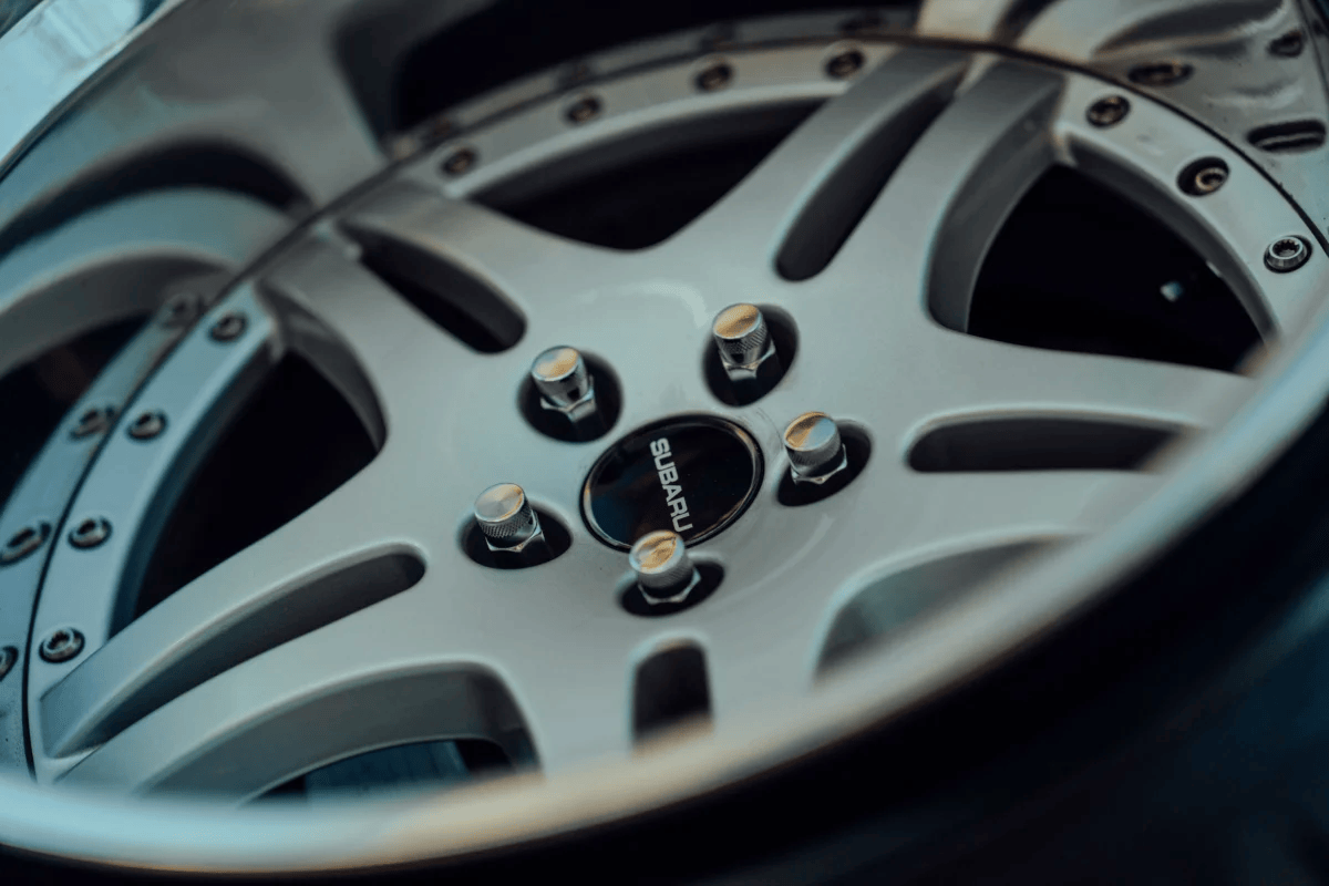 Detailed close-up of a silver alloy wheel with visible bolts, emphasizing design.