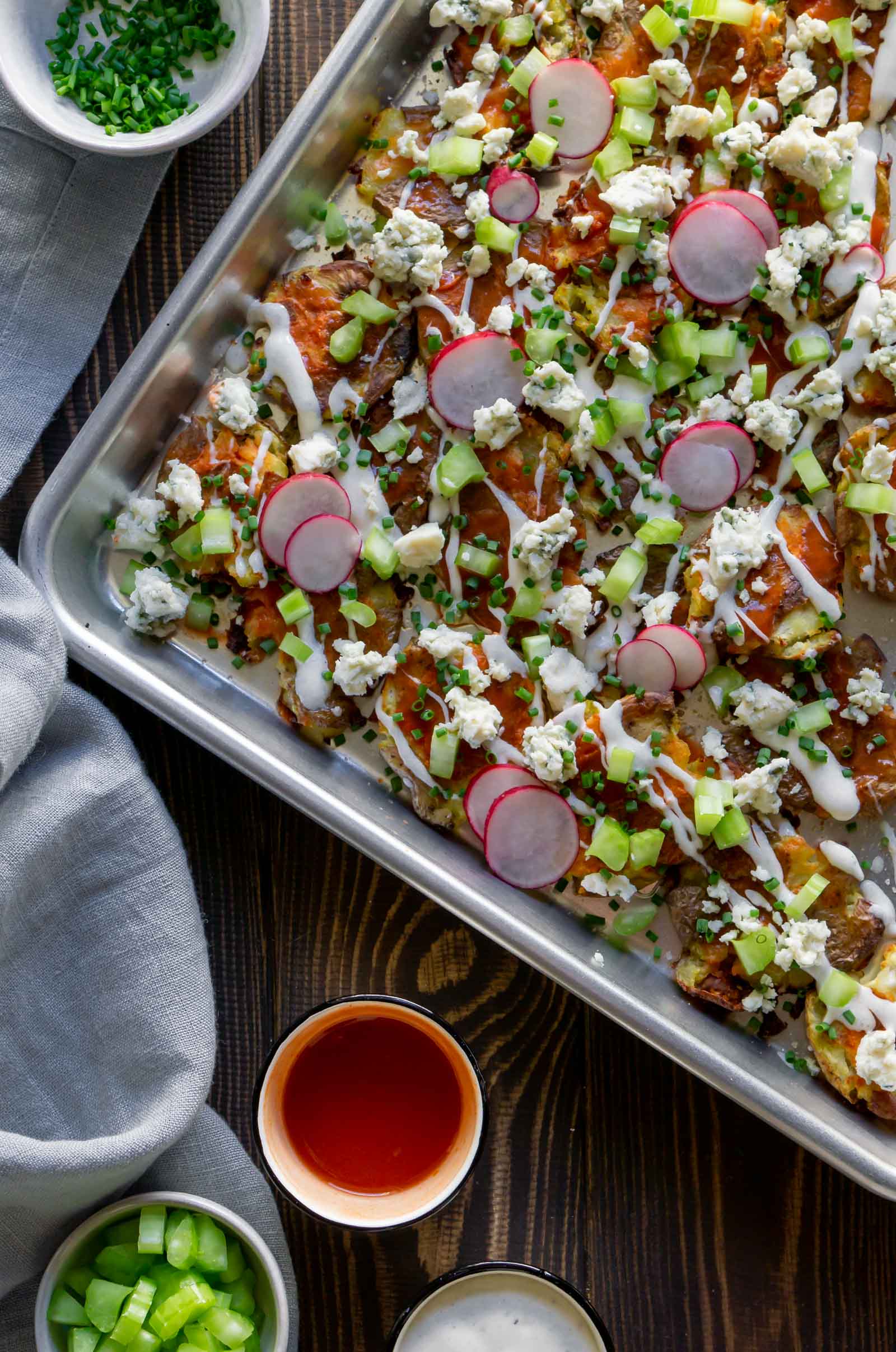 overhead photo of smashed potatoes loaded nachos on a tray
