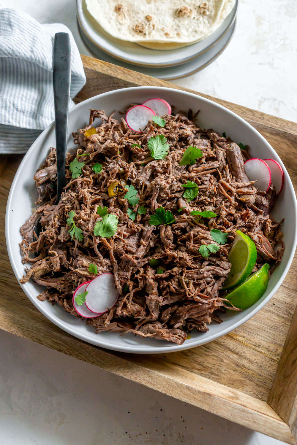 Chipotle barbacoa in a white bowl on a tray.