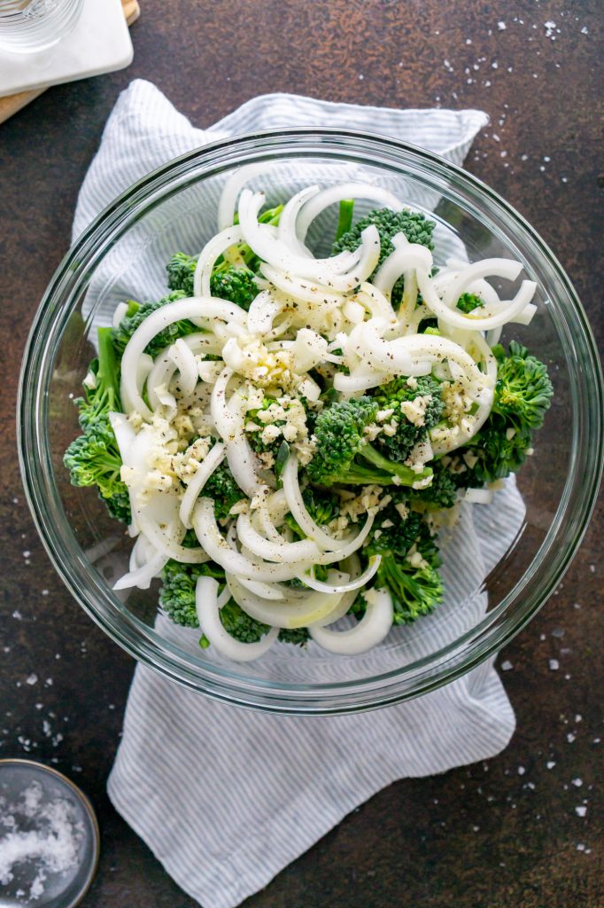 brococlini and onions in a mixing bowl