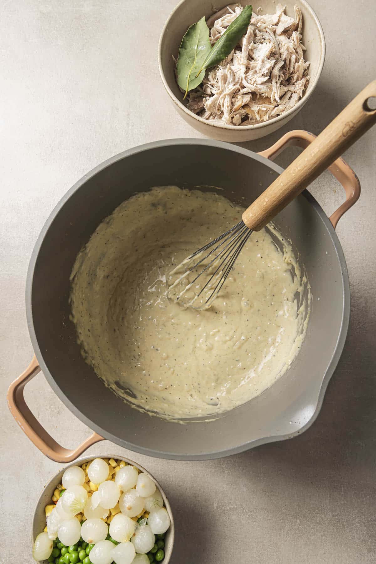 Whisking a creamy sauce in a large pot.