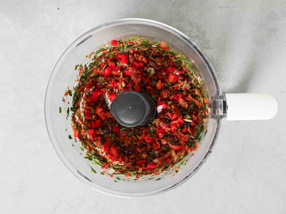 Pulsing the ingredients for corn salsa in a food processor. 