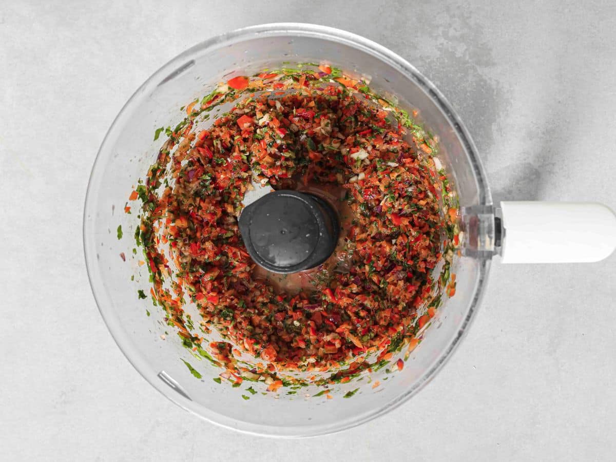 Adding the dressing to the food processor and pulsing. 