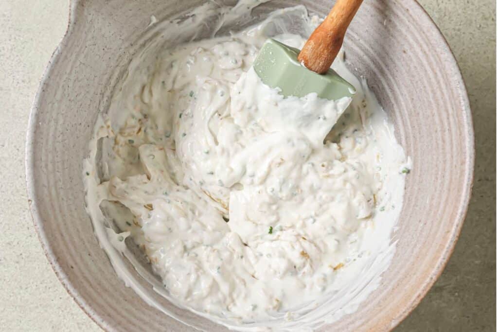 French onion dip ingredients combined in a large mixing bowl.