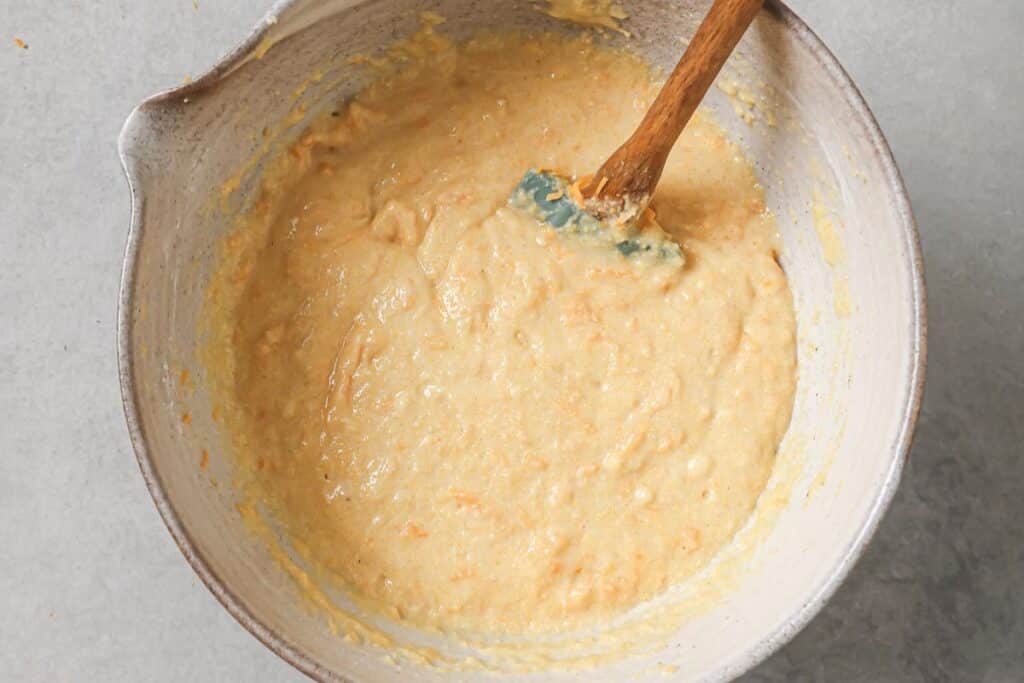 Mixing the wet and dry cornbread ingredients together and folding in the cheddar cheese.