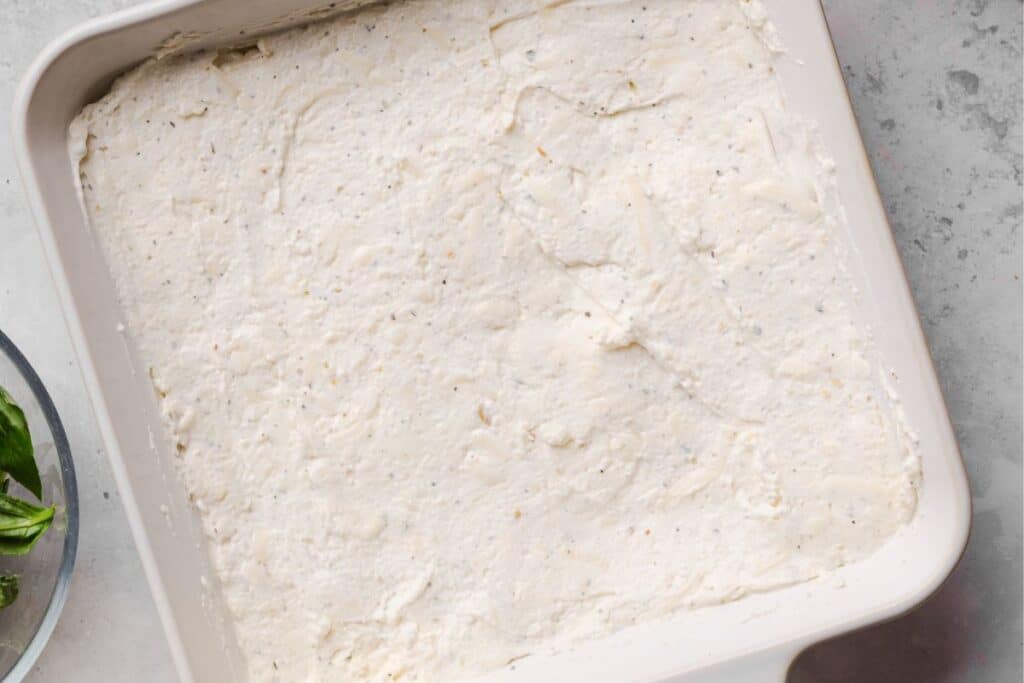 The pizza dip base spread into an 8x8 square pan. 