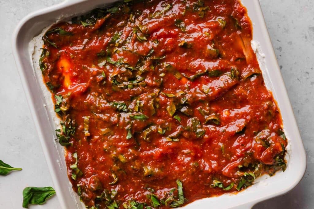 Sauce and basil added to the top of the cream cheese base. 