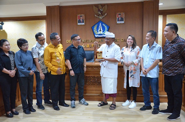 Wakil Ketua Komisi III DPRD Badung, I Nyoman Satria,S.Sos ( pakaian adat) saat menyerahkan Cendera Mata kepada rombongan Pansus Penyertaan Modal DPRD Kota Bitung Sulawesi Utara, Kamis (7/12/2023)-kabarbalihits