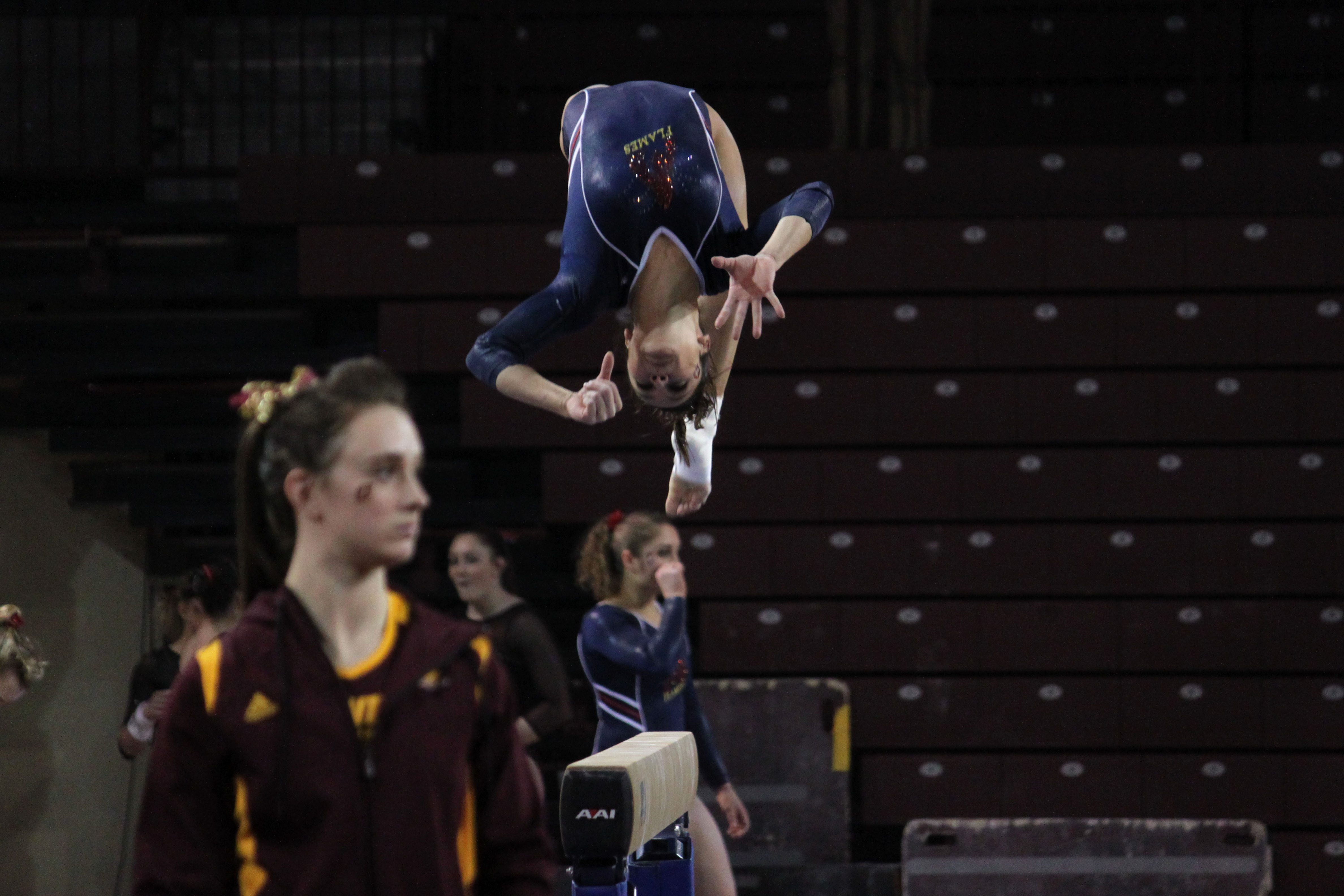 A member of University Illinois Chicago warms up on the bar at the Illinois invitational at Central Michigan University on March 11, 2014.