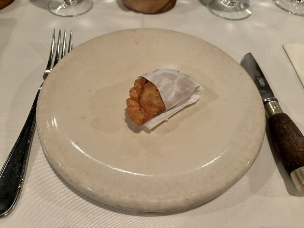 Before the menu: Mini empanada lying on a white plate Welcome Empanada at Parrilla Don Julio Buenos Aires