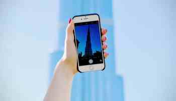 person holding silver iPhone 6 and black case