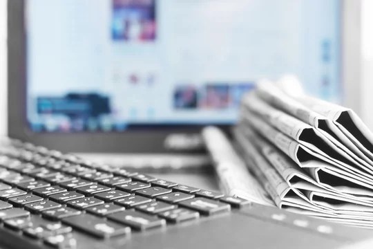 Computer screen and keyboard and folded newspapers