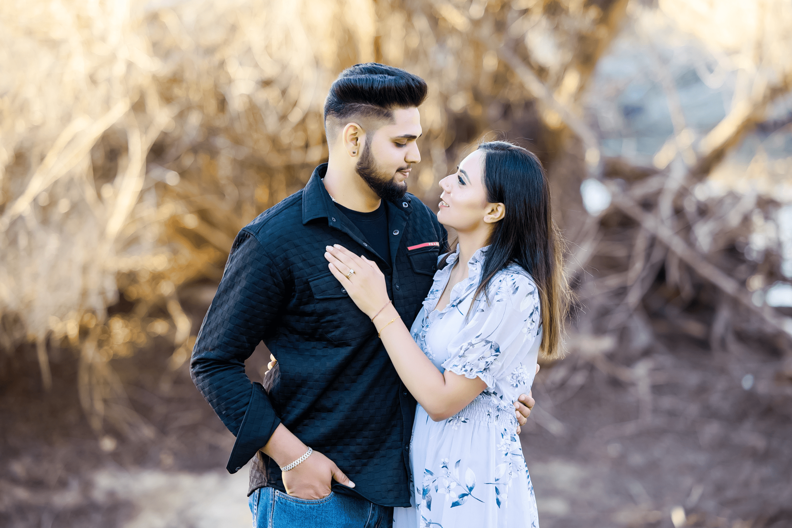 Close-up of couple (Love & Arashdeep) embracing, looking into each other’s eyes with a soft, warm background.