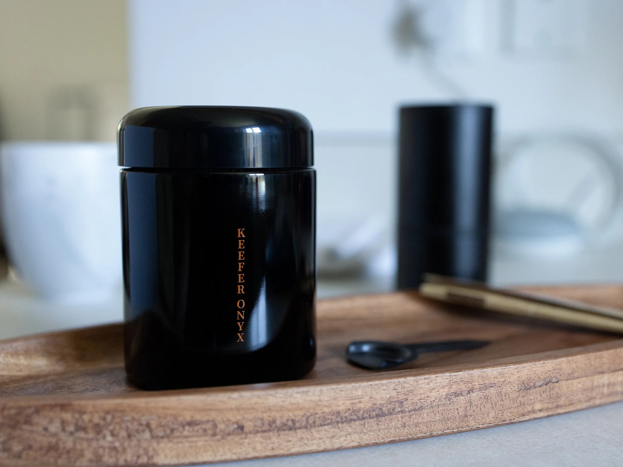 Black glass Keefer Onyx stash jar on a wooden tray, styled as home décor