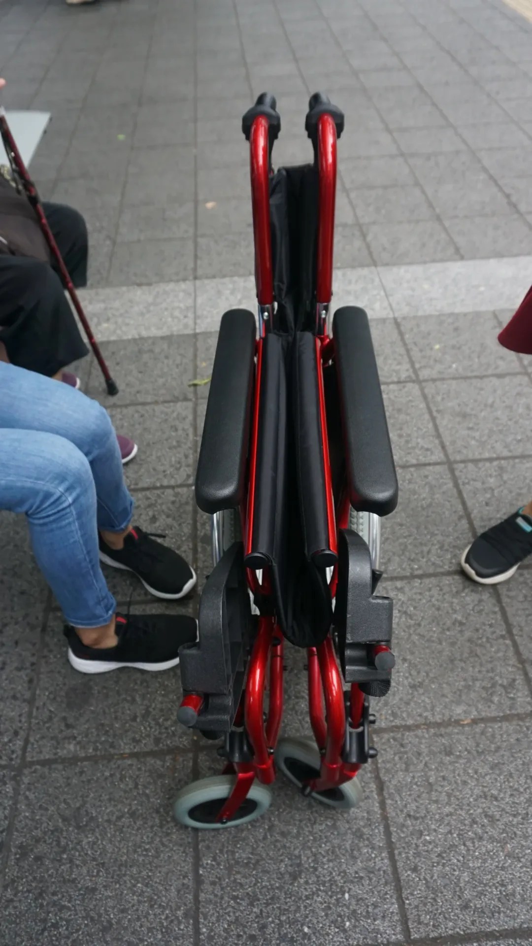 A folded red wheelchair