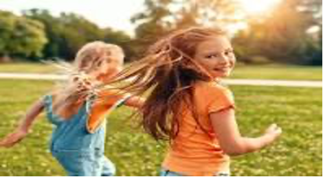example of happiness. as two youngsters run, laugh, and play