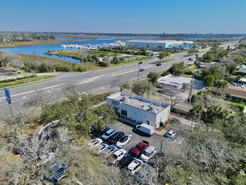 Drone shot of Le Petit Paris French Café, showing its location at San Pablo Road with scenic waterfront views.