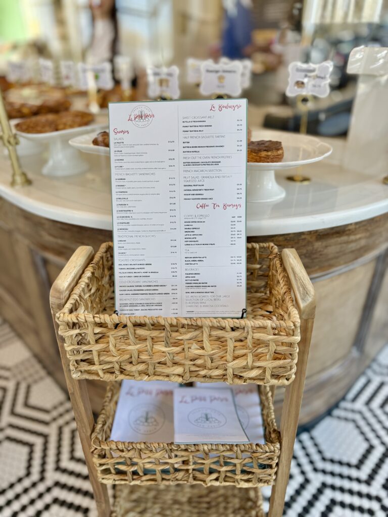 Le Petit Paris French Café’s printed menu displayed on a stylish woven basket inside the café.