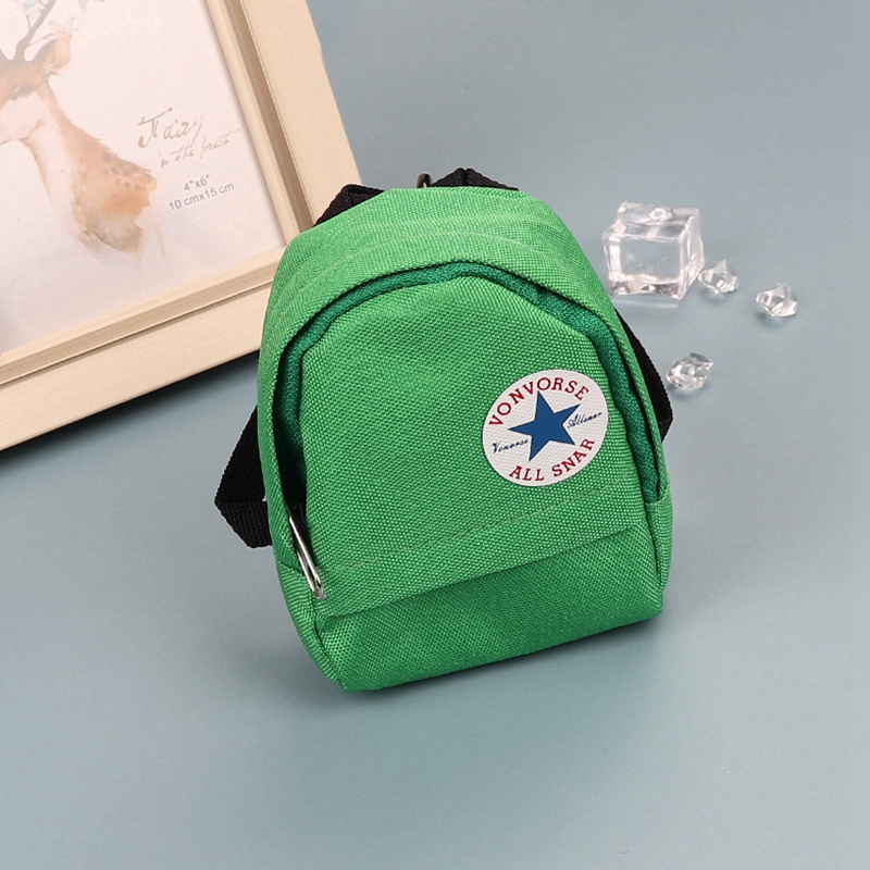 Green mini canvas backpack keychain with white circular logo.