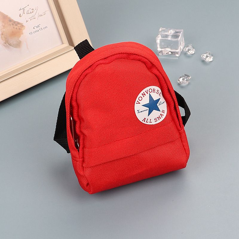 Red mini canvas backpack keychain with white circular logo.