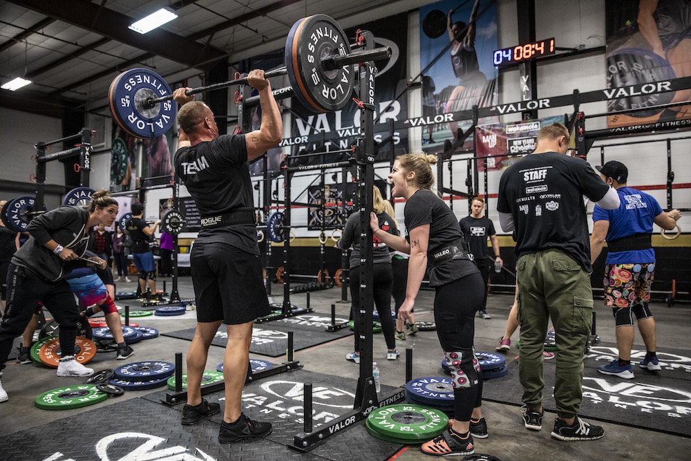 Local athletes conquer fitness competition - A group of people riding on a skateboard - Weight training