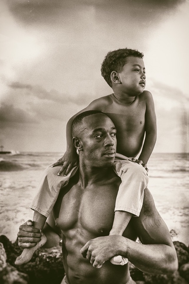 Familiar Faces of Fathers from Key West, Marathon, and the Upper Keys - A young boy standing next to a body of water - Gallery On Greene