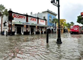 What FEMA flood maps mean for residents, real estate - A group of people walking down a street next to water - Sloppy Joe's Bar