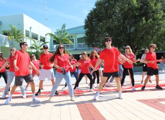 a group of people in red shirts are dancing