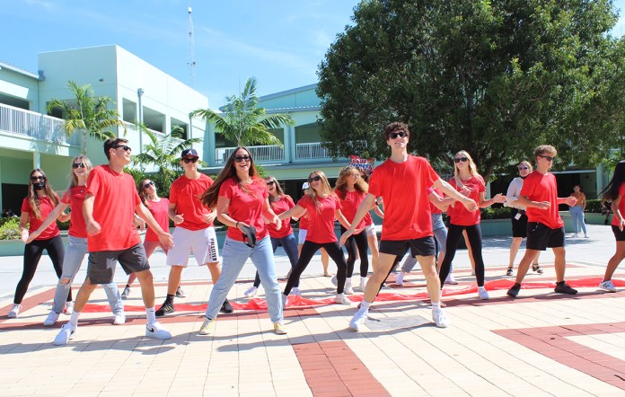 a group of people in red shirts are dancing