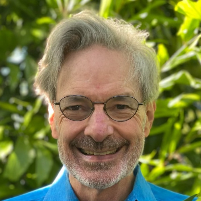 a close up of a person wearing glasses and a blue shirt