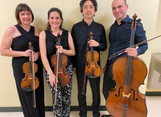 QUARTET PERFORMANCE DEDICATED TO LATE COUNTY COMMISSIONER a group of people standing next to each other holding musical instruments