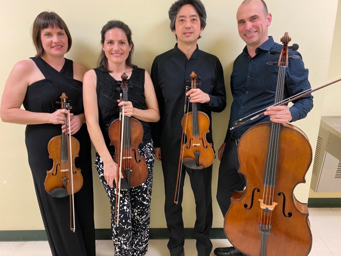 Jupiter String Quartet a group of people standing next to each other holding musical instruments