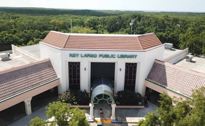 an aerial view of a building with trees in the background