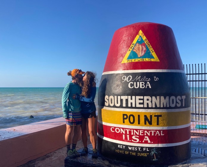 ECT4 Large two girls standing next to a sign on the beach