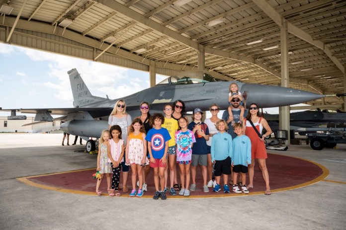 a group of people standing in front of a fighter jet