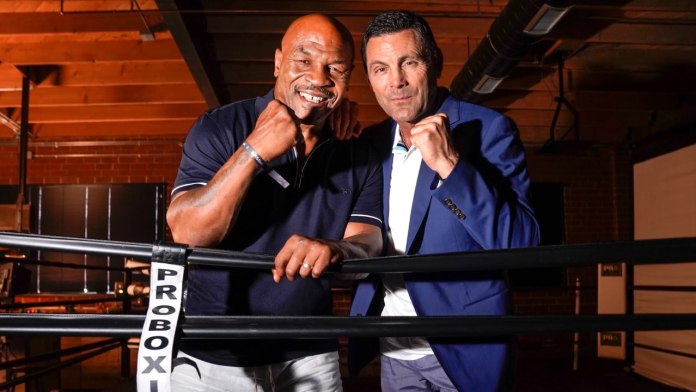 two men standing next to each other in a boxing ring