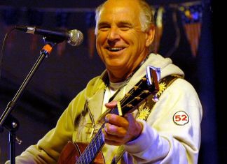 JOHN BARTUS: REMEMBERING JIMMY BUFFETT a man playing a guitar and singing into a microphone