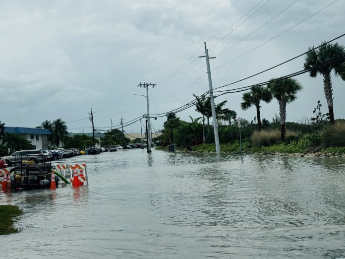 FullSizeRender a flooded street with cars parked on the side of it