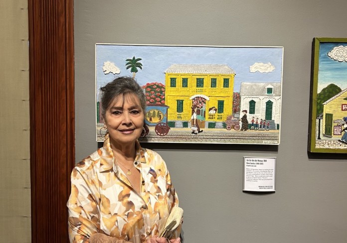 a woman standing in front of paintings on a wall