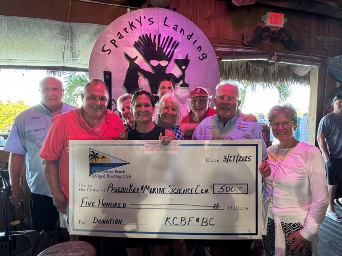 a group of people standing around a giant check