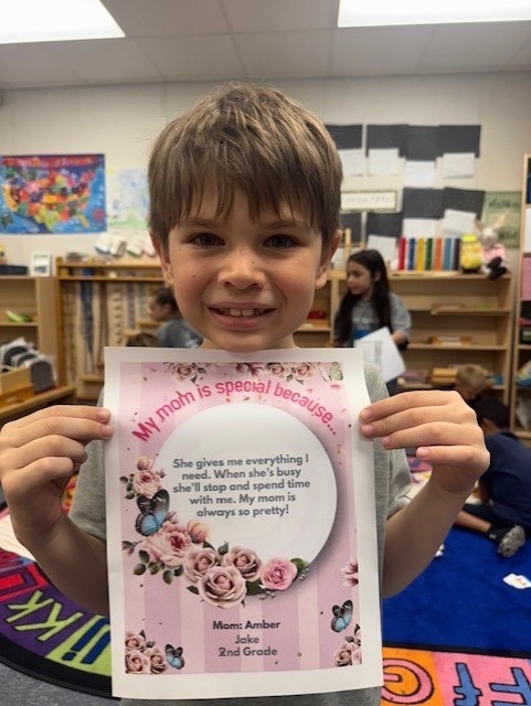 a young boy holding up a card with a poem on it