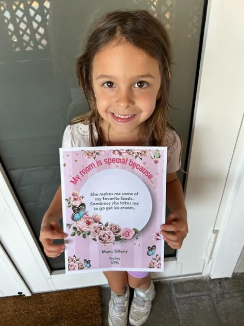 a little girl holding up a card with a quote on it
