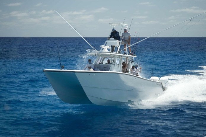 a white boat with people on it in the ocean