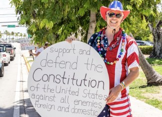 IN PICTURES: ‘GOOD TROUBLE’ RALLY HONORS LATE CONGRESSMAN JOHN LEWIS’S MISSION a man in a patriotic outfit holding a sign