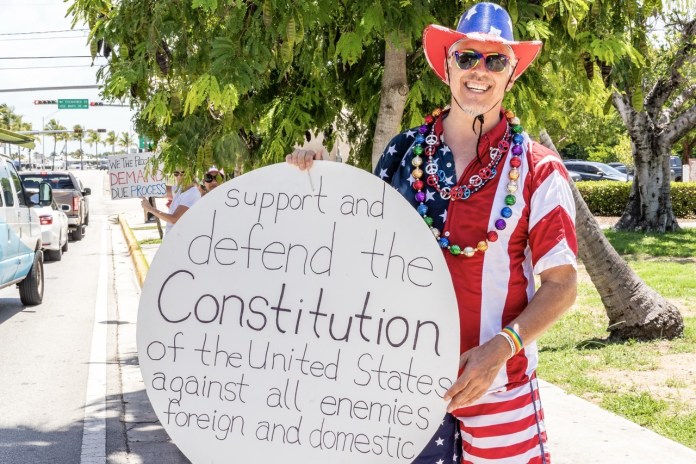 Good Trouble Rally 2025 NWM--7 Large a man in a patriotic outfit holding a sign