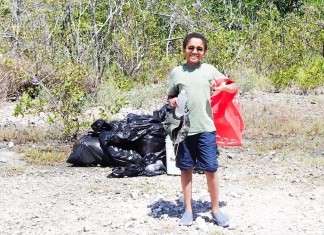 SHORELINE CLEANUPS HONOR THE LIFE OF PASCAL WEISBERGER a man standing in the dirt with a red bag