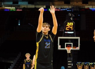 a young man standing on top of a basketball court