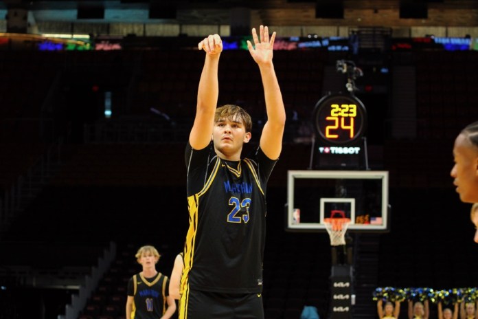 2 a young man standing on top of a basketball court
